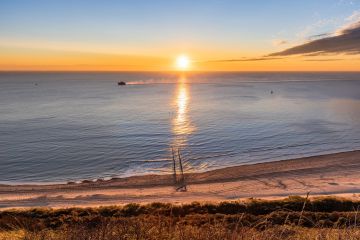 Wie die Sonne bei Valkenisse im Meer versinkte